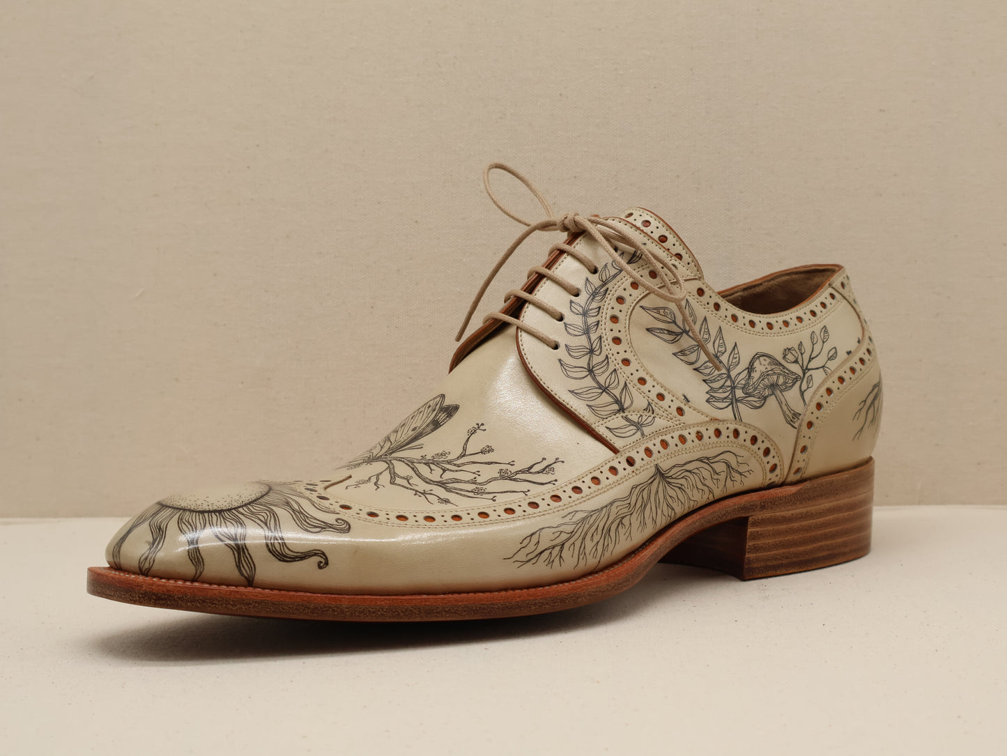 Bespoke Long Wingtip Derby in Natural Vegetable-Tanned English Box Calf, featuring intricate hand-tattooed artwork and detailed broguing. A fusion of traditional craftsmanship and artistic expression, completed with a Goodyear-welted leather sole by euGo, The Art of Shoemaking, Burlingame, California.