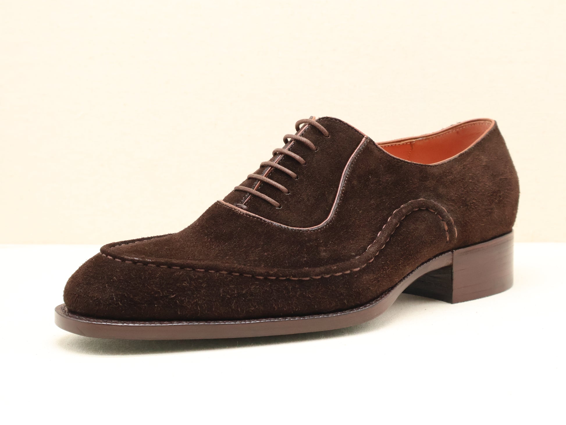 Bespoke Wholecut Oxford in Chocolate Suede, featuring a unique hand-stitched apron-style toe that adds subtle character to its seamless design. Handcrafted from fine English suede and finished with a Goodyear-welted leather sole by euGo, The Art of Shoemaking, Burlingame, California.