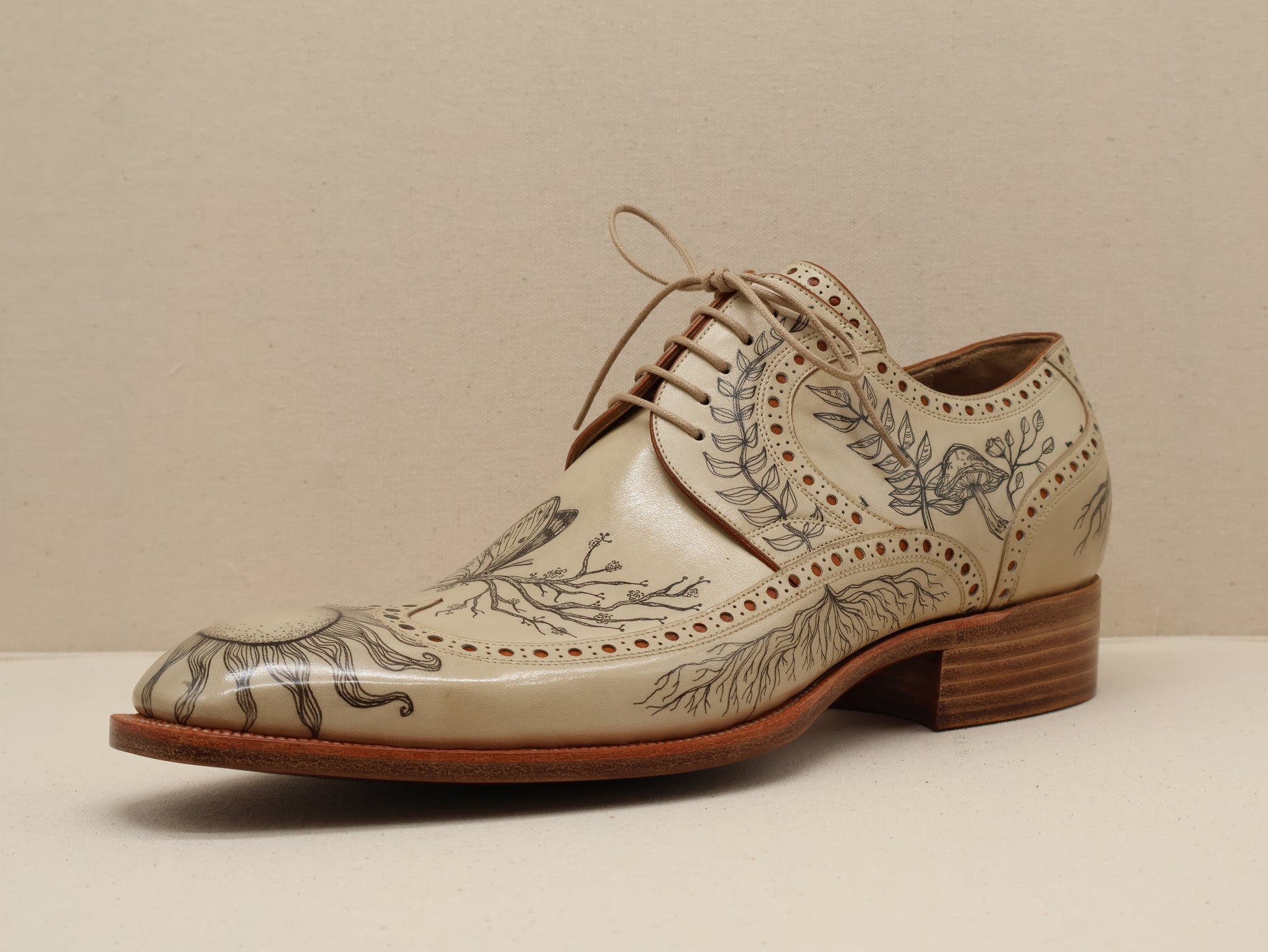 Bespoke Long Wingtip Derby in Natural Vegetable-Tanned English Box Calf, featuring intricate hand-tattooed artwork and detailed broguing. A fusion of traditional craftsmanship and artistic expression, completed with a Goodyear-welted leather sole by euGo, The Art of Shoemaking, Burlingame, California.